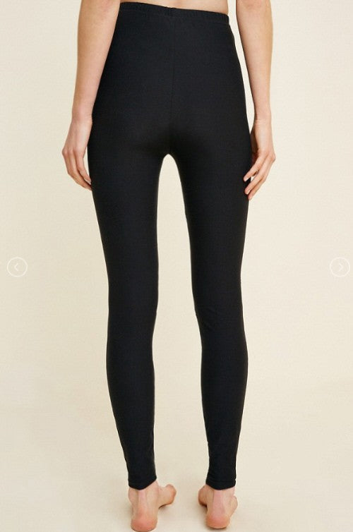 Närbild på svarta slimfit damleggings, visar unika spetsutskärningar på benet. Bekväma & stilfulla för modern look.