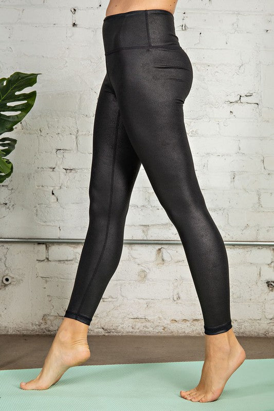 Kvinna i svarta stretchiga träningsleggings, perfekt för yoga eller löpning. Hög midja ger stöd och komfort.