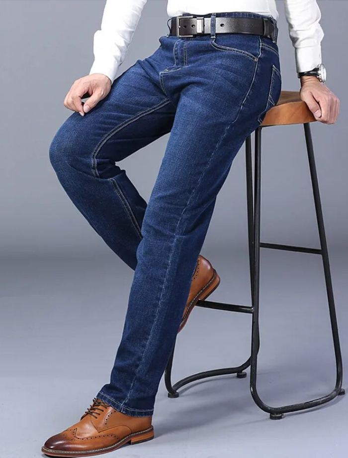 Man bär blå herr stretchjeans med normal passform. Bekväma byxor för en stilren, mångsidig vardagslook.