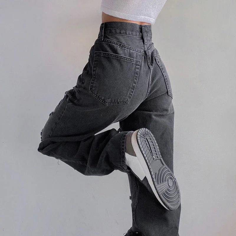 Närbild av rippade jeans för kvinnor, visar den råa fållen och den slitna denimen, trendigt mode