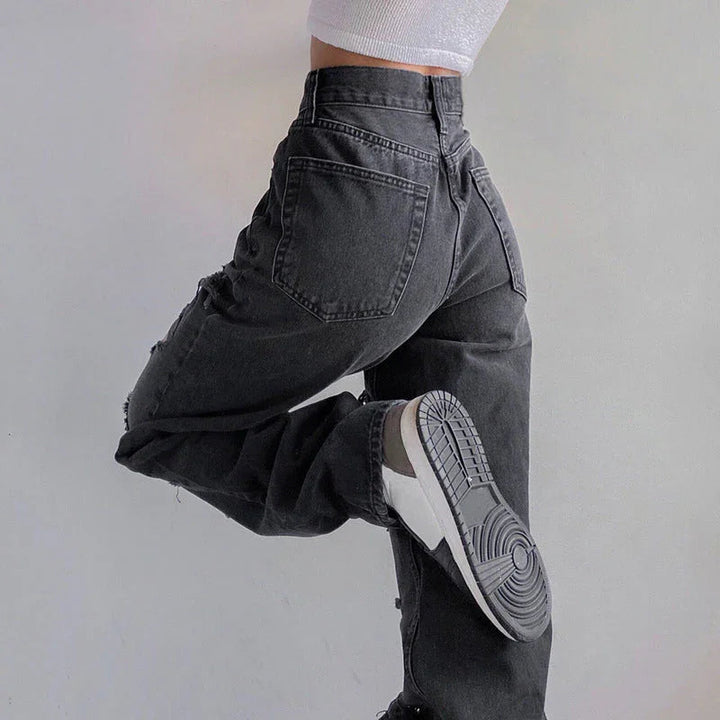 Närbild av rippade jeans för kvinnor, visar den råa fållen och den slitna denimen, trendigt mode