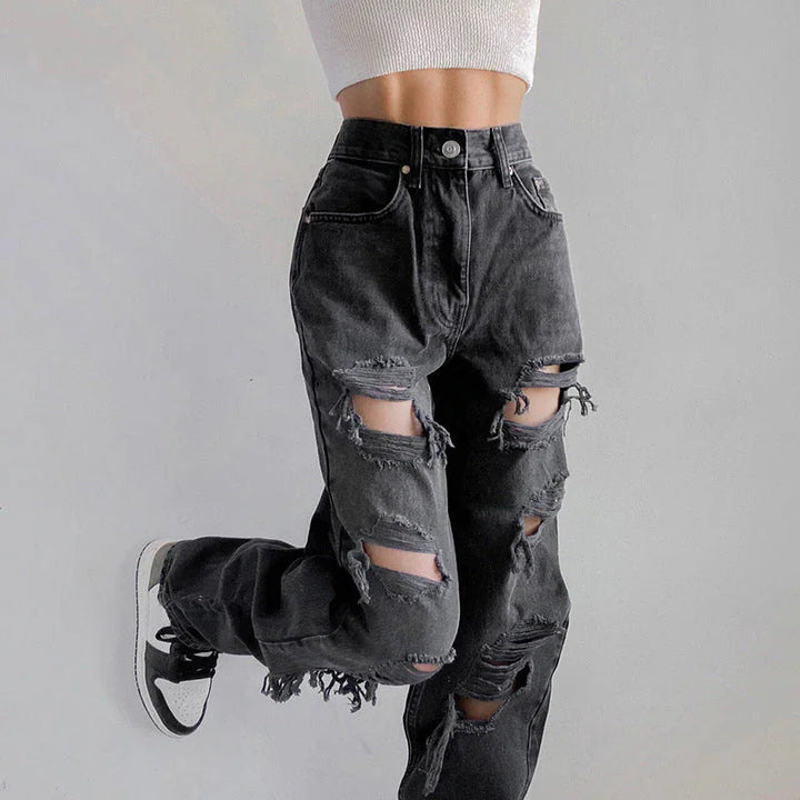 Helfigur av kvinna som bär svarta rippade jeans med rå fåll, idealisk för en avslappnad vårlook