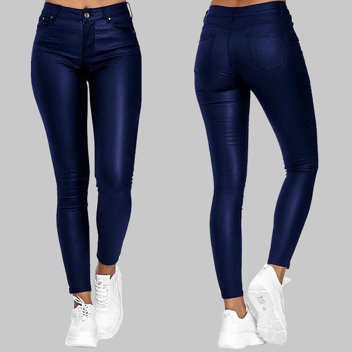 Röda modebyxor i konstläder, slim fit och hög midja, en trendig detalj för damer.