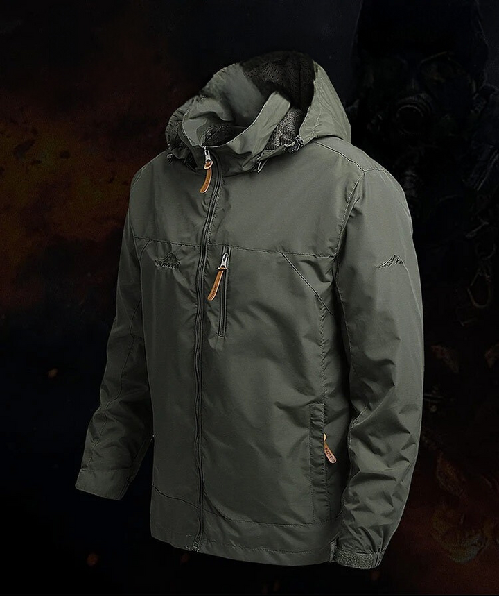 Lifestylebild: Man i taktisk windbreakerjacka med naturlandskap i bakgrunden.