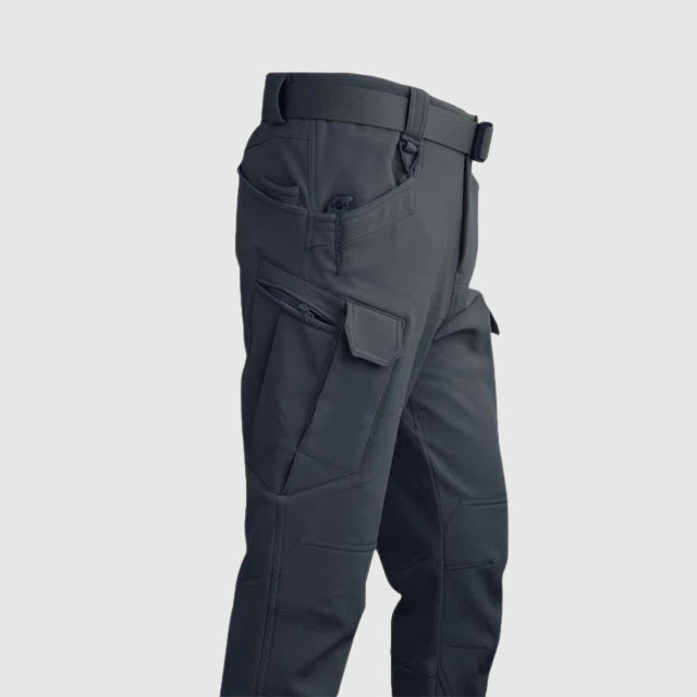 Detaljbild av taktiskt herrjacka och byxset, designat för maximal funktion och komfort utomhus.