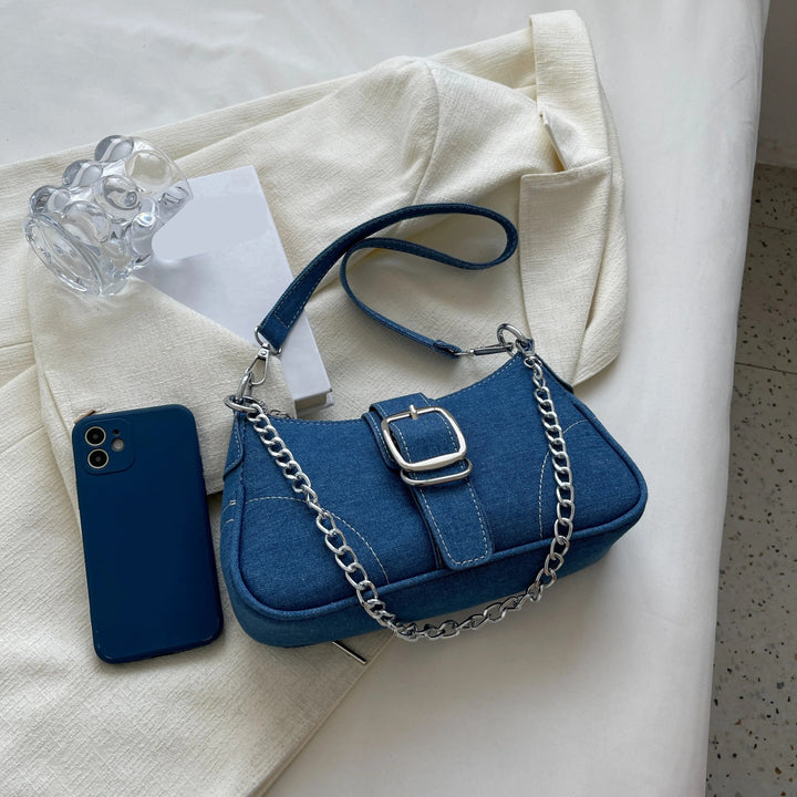 Detaljerad crossbody-väska för dam i trendig jeanslook, med justerbar axelrem.