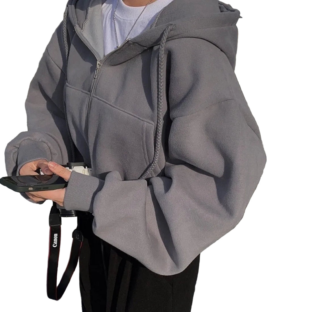 Trendig kvinnors hoodie med dragkedja, avslappnad passform och sluttande axlar för modern vardagsstil.