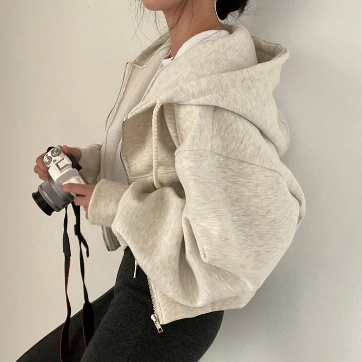 Kvinnors trendiga zip-hoodie med unika sluttande axlar, idealisk för en avslappnad och modern vardagslook.