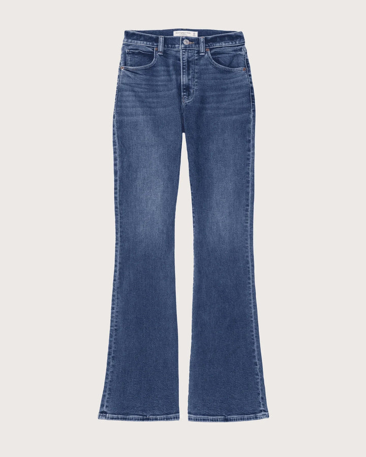 Helfigur av kvinna som bär avslappnade damjeans med hög midja och lös passform, i en modebild.