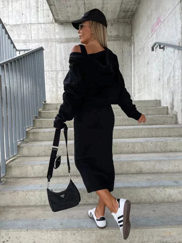 Svart kvinnors klänning och kofta set. Trendig tvådelad stil perfekt för hösten.