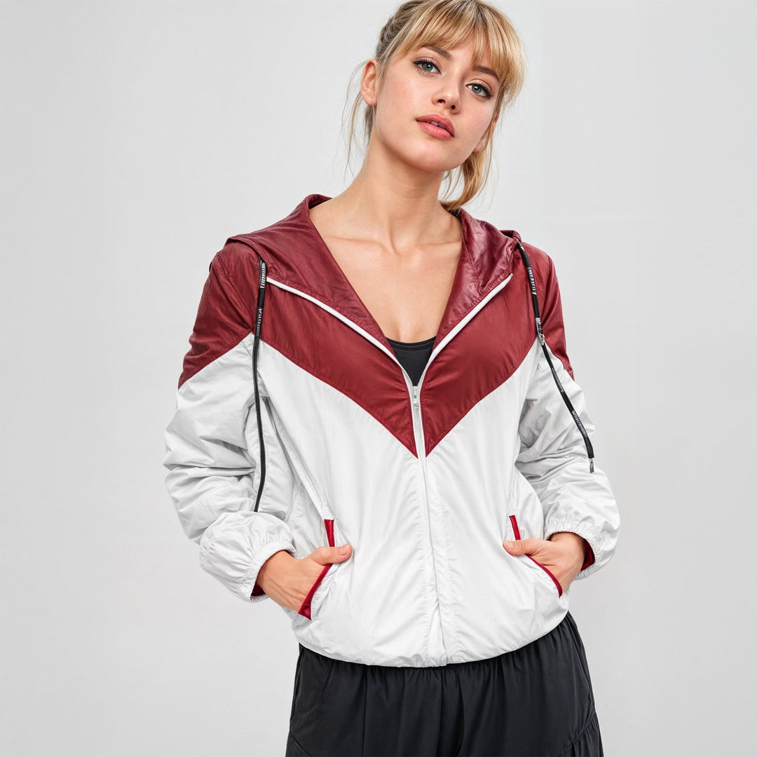 Sportig damjacka i två färger, allvädersfunktion och streetwear-känsla med huva.