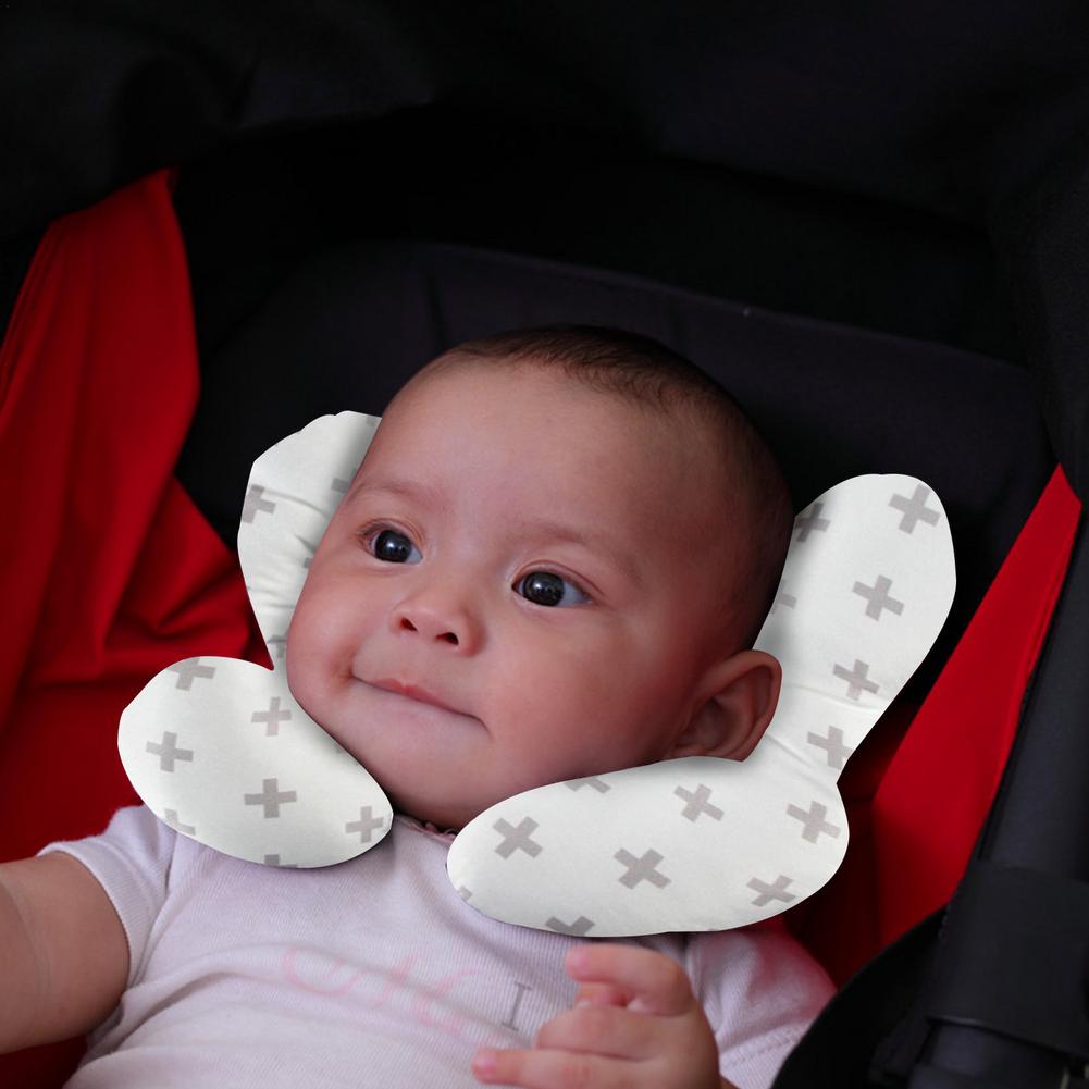 Närbild på en u-formad babykudde, visar det mjuka materialet och den ergonomiska formen för spädbarn