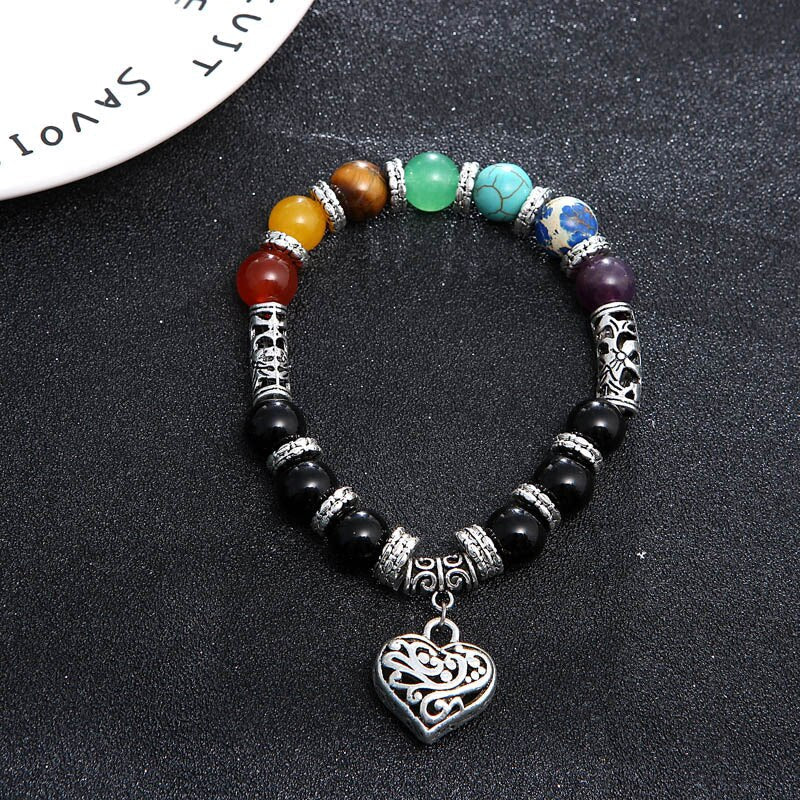 Handled som bär unisex 7 Chakra healing naturstensarmband, detalj av karneol och röd jaspis