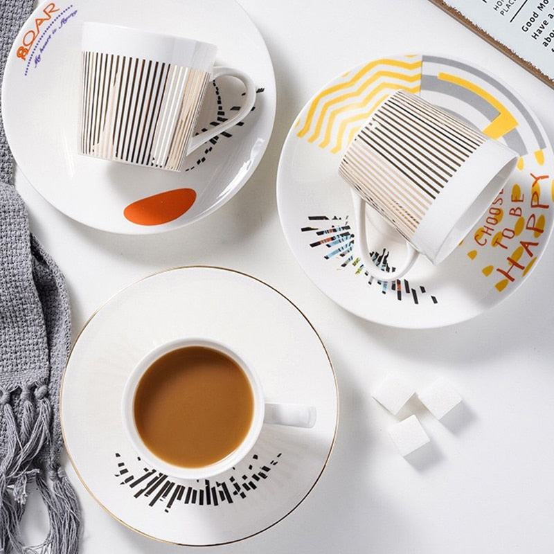 Keramik kaffekopp med lekfull design, matchande fat och sked, perfekt heminredning present.