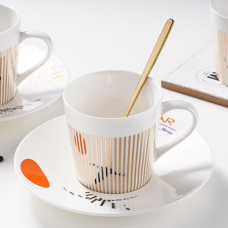Toppvy: unik animerad kaffekopp, fat och sked set i keramik, perfekt för present.