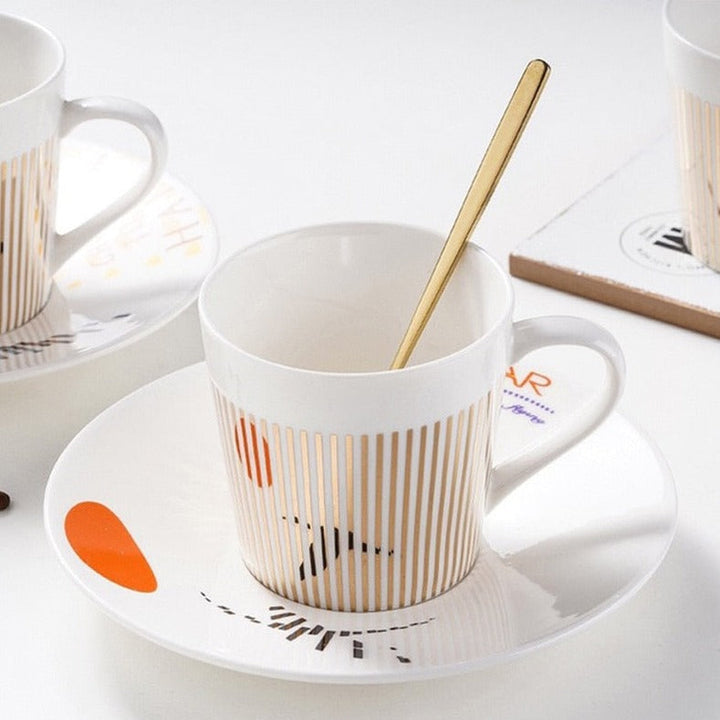 Toppvy: unik animerad kaffekopp, fat och sked set i keramik, perfekt för present.