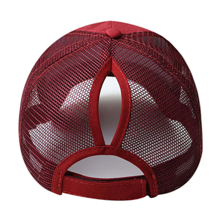 En person bär bekväm, hårvänlig unisex hästsvanskeps i polyester/bomull. Perfekt för utomhus.