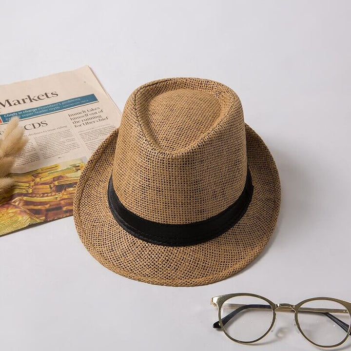 Unisex sommarfedora av halm, placerad på en trädgårdsstol, redo för soliga dagar.