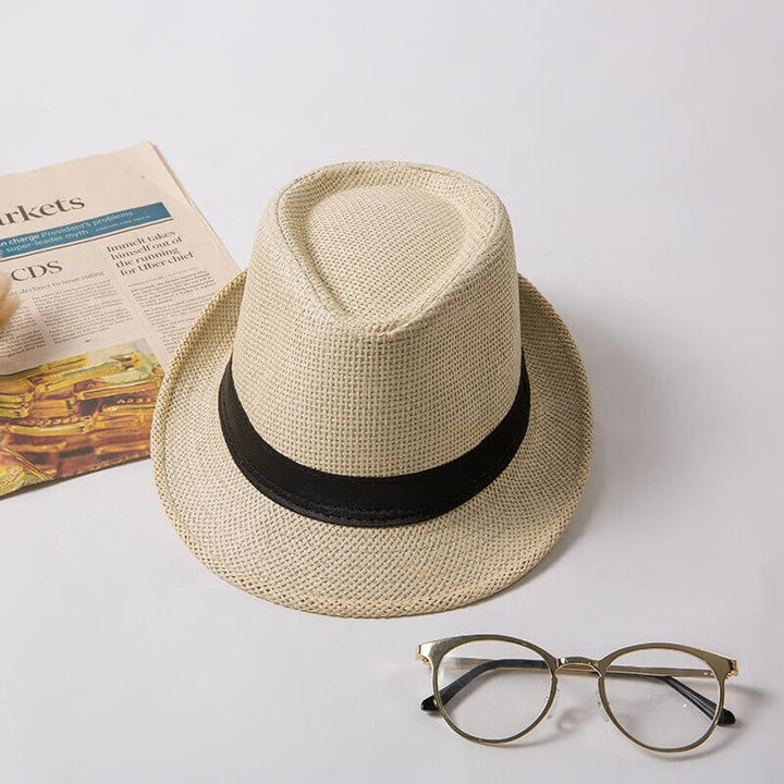 Unisex halmhatt med fedora design, bärs avslappnat av en person, perfekt för casual look.