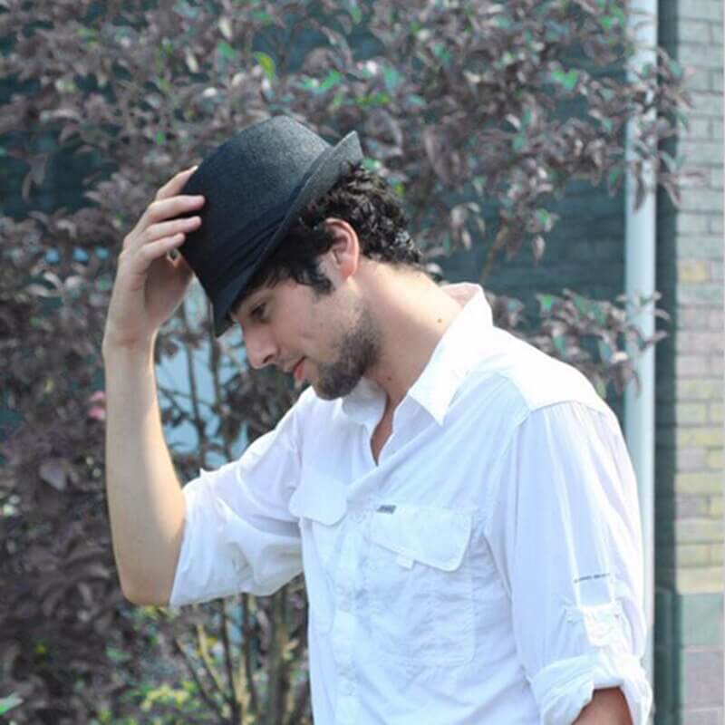 Unisex fedora sommarhatt, diskret placerad på en strandfilt, redo för en dag i solen.
