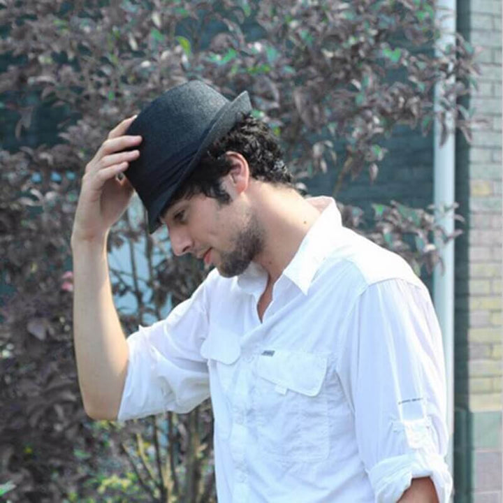 Unisex fedora sommarhatt, diskret placerad på en strandfilt, redo för en dag i solen.