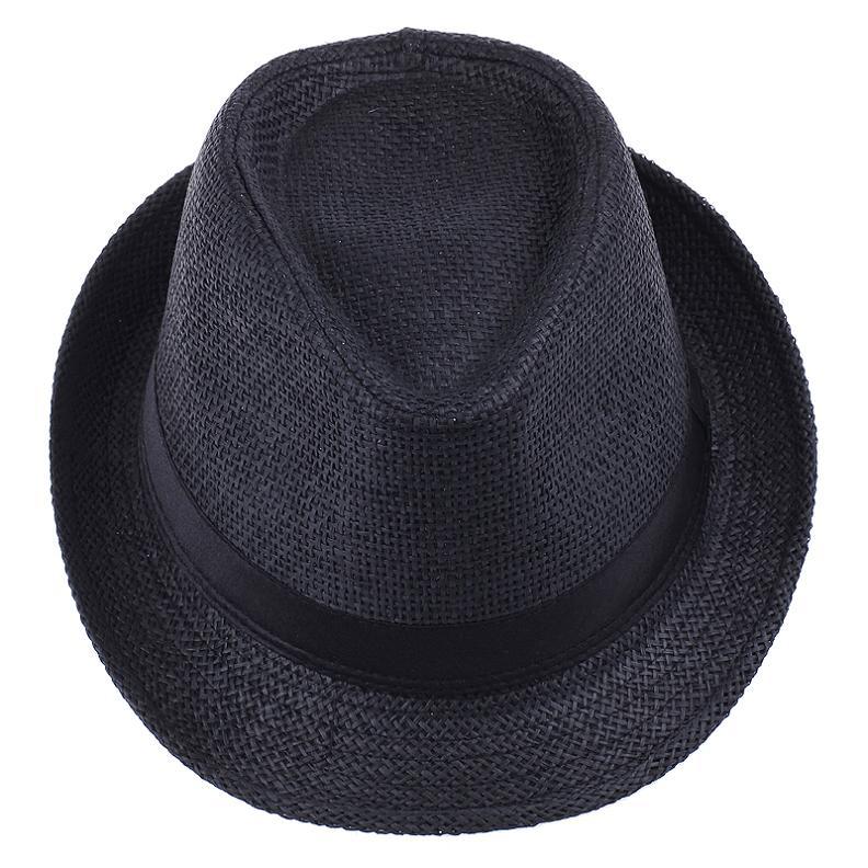 Unisex fedora halmhatt med brett brätte, bärs av en person utomhus, för soligt väder.
