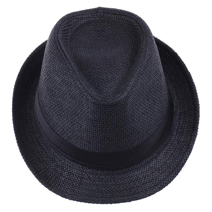 Unisex fedora halmhatt med brett brätte, bärs av en person utomhus, för soligt väder.