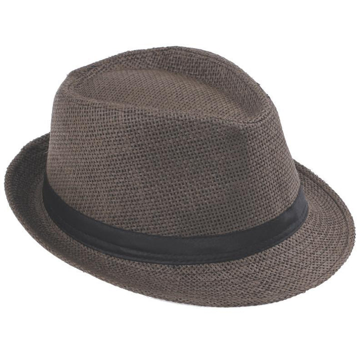 Unisex halmhatt, fedora stil, ligger på en sandstrand, en semesterklar accessoar.