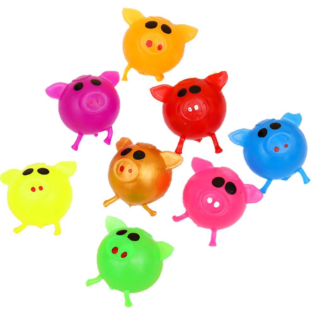 Glad flicka leker med en rosa gris splatboll leksak, stressreducerande presentidé för barn.