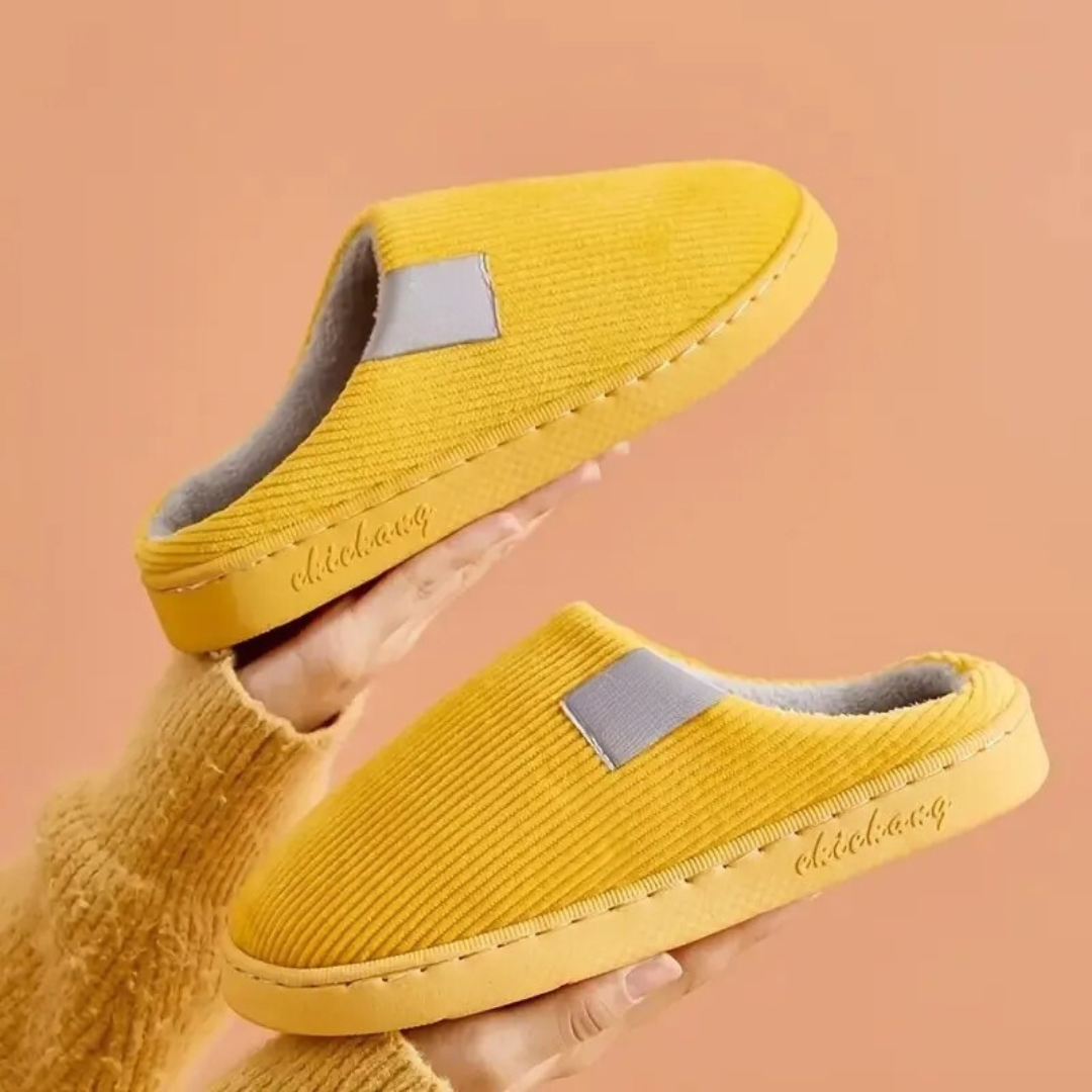 Mjuka, termiska unisex-tofflor i en neutral färg, visade uppifrån med mjuk botten.