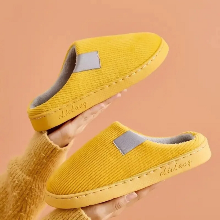 Mjuka, termiska unisex-tofflor i en neutral färg, visade uppifrån med mjuk botten.