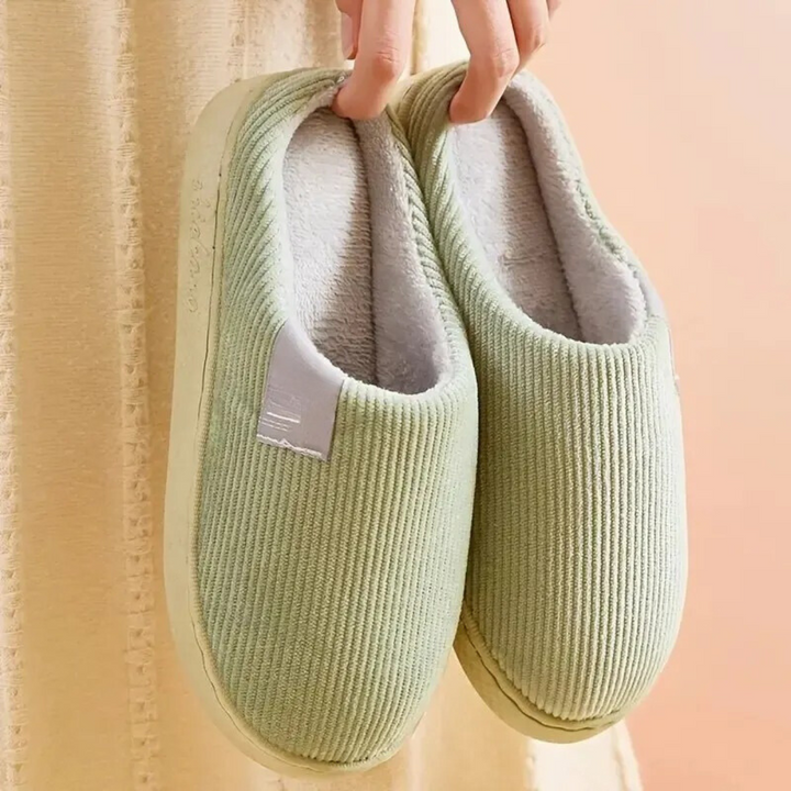 Ett par termiska unisex-hemmaskor i tyg, med mjuk botten och halkskydd för komfort.