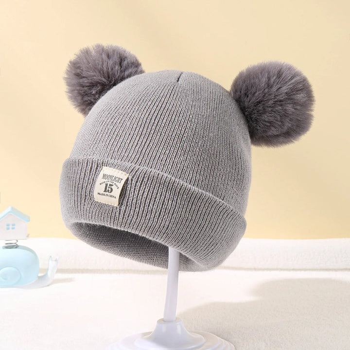 Mörkgrå unisex babymössa i stickad ull, en praktisk och stilren vinteraccessoar för barn.