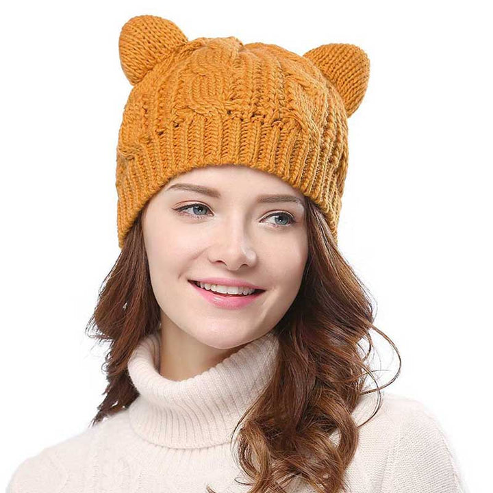 Mysig stickad vintermössa med charmiga kattöron, en söt och varm accessoar.