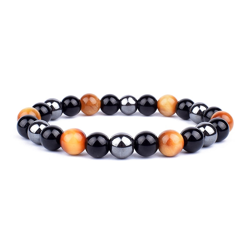 Detaljbild av de unika naturstenarna i unisexarmbandet för trippelskydd; tigeröga, hematit, obsidian.