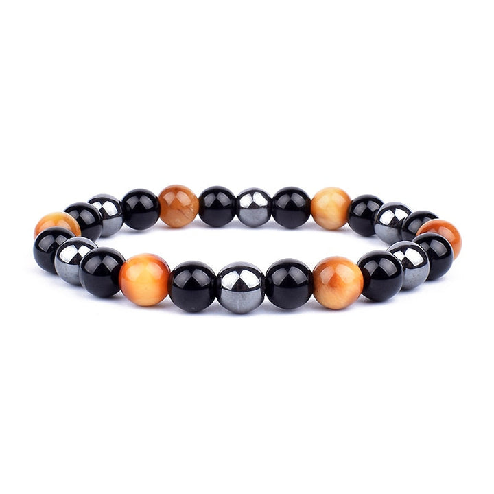 Detaljbild av de unika naturstenarna i unisexarmbandet för trippelskydd; tigeröga, hematit, obsidian.