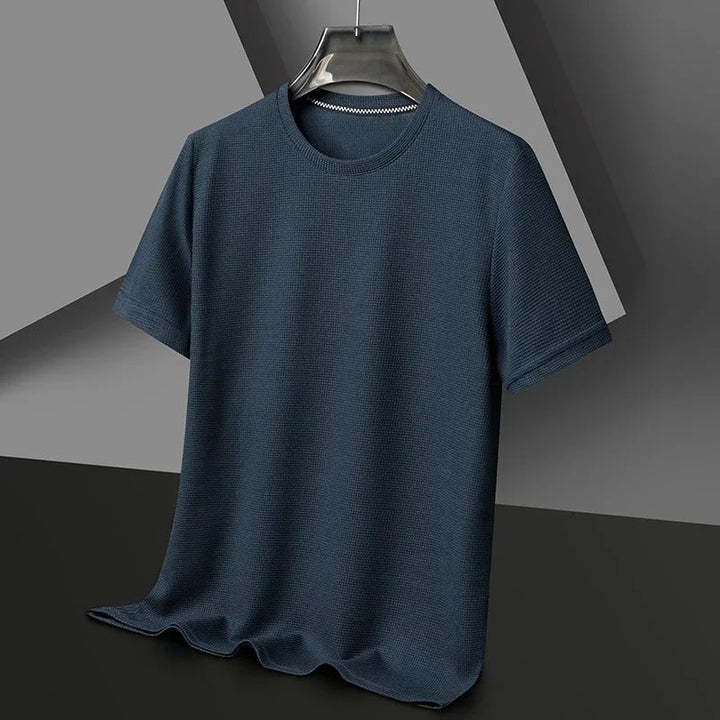 Enfärgad våfflad t-shirt för män. Lätt att kombinera, idealisk för sommar och mångsidiga looks.