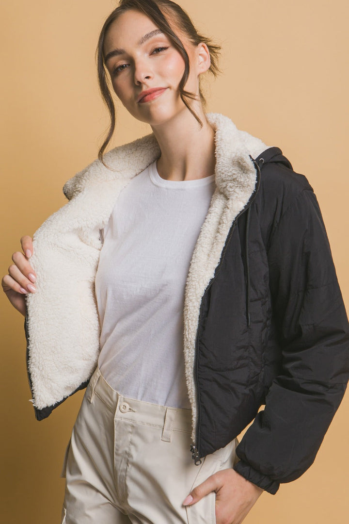 Trendig svart croppad damjacka med huva. Vändbar design för urban modejacka, vardagsstil.