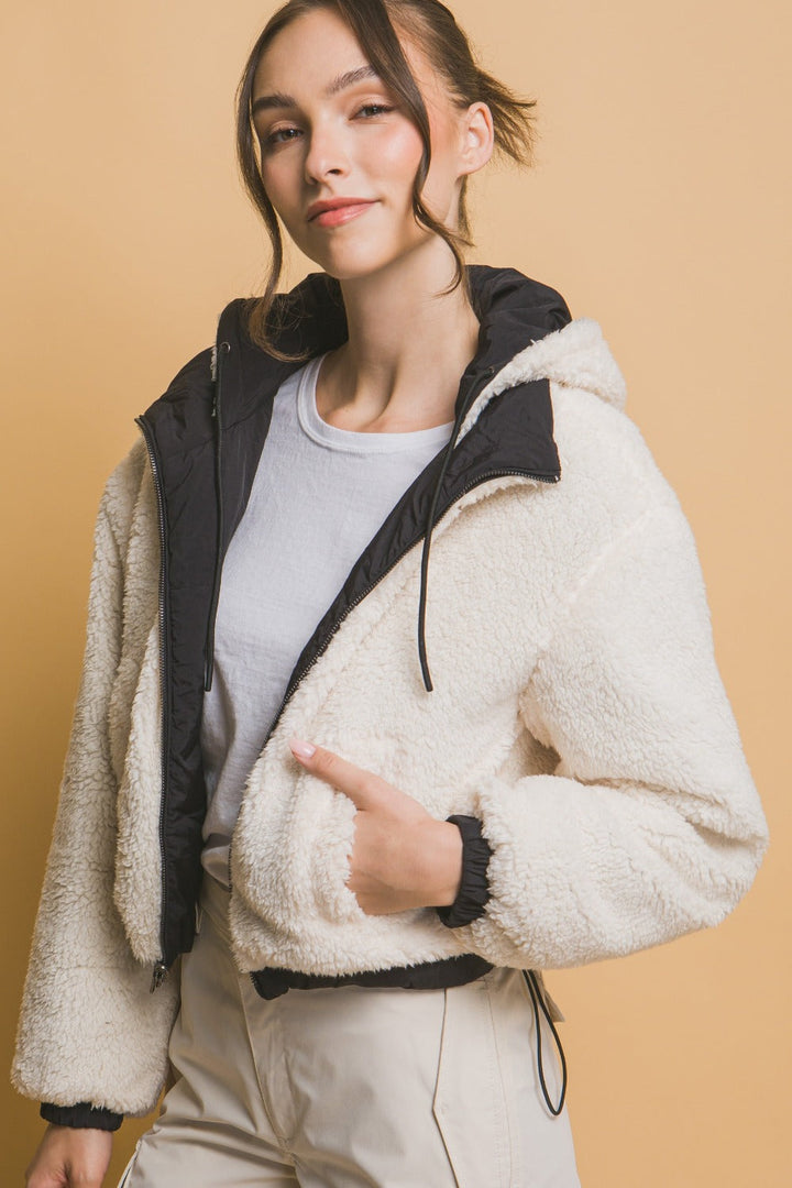 Svart vändbar jacka med huva för dam. Croppad modell för dubbel stil, perfekt urban modejacka.