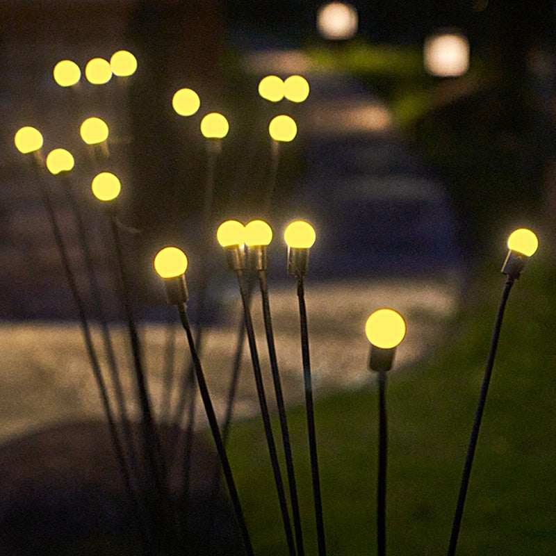 Nattbild på vajande solcells LED-ljus. Eldflugseffekt lyser upp trädgården. Perfekt stämningsskapande utebelysning.