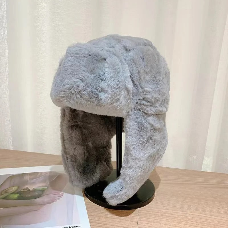 Håll dig varm med denna mysiga, stickade vintermössa för damer. Trendig beanie med öronlappar.