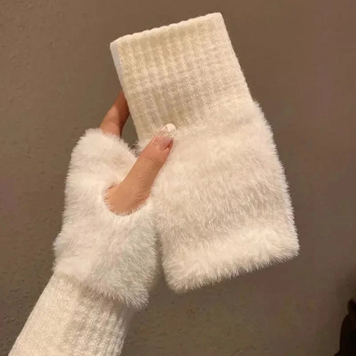 Närbild på dam halvfingerhandskar, visar detaljer av den varma och mjuka stickningen.