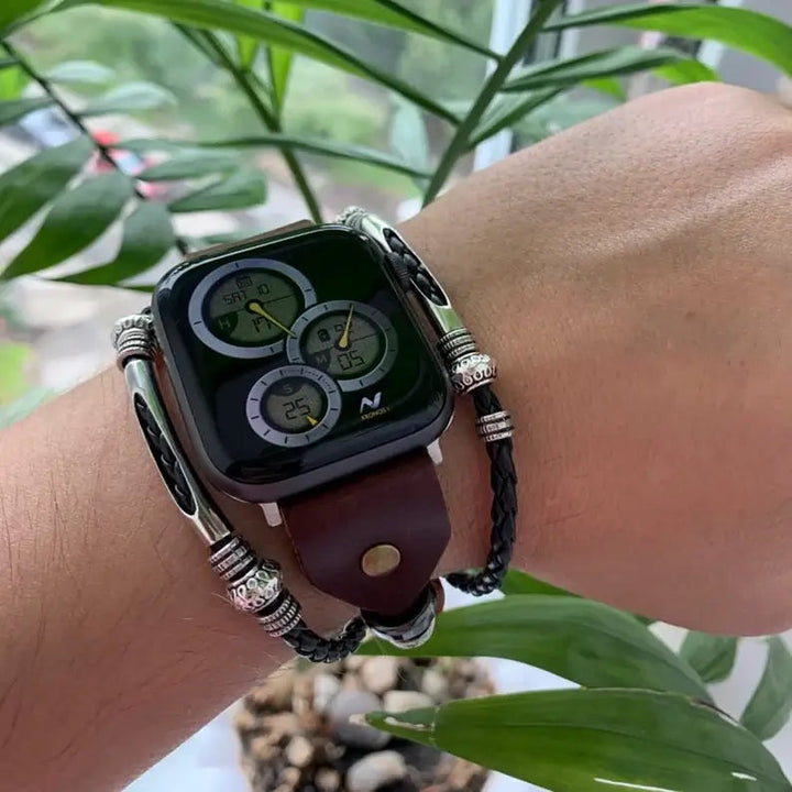 Svart vintage läderarmband liggande bredvid en Apple Watch, smartklocka