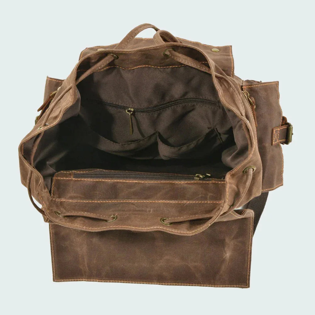 En person bär en trendig, vintage unisex ryggsäck med dragsko under en promenad i naturen.