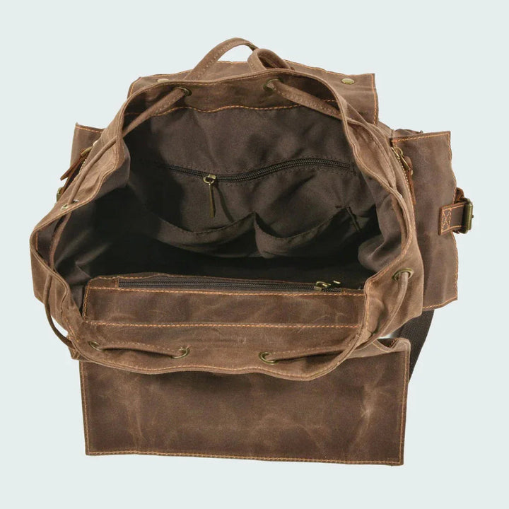 En person bär en trendig, vintage unisex ryggsäck med dragsko under en promenad i naturen.