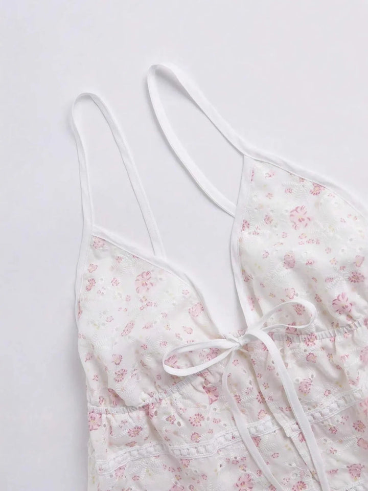 Närbild på vit blommig cami topp med knytning fram, visar ärmlös design för kvinnor. Sommar casual linne.