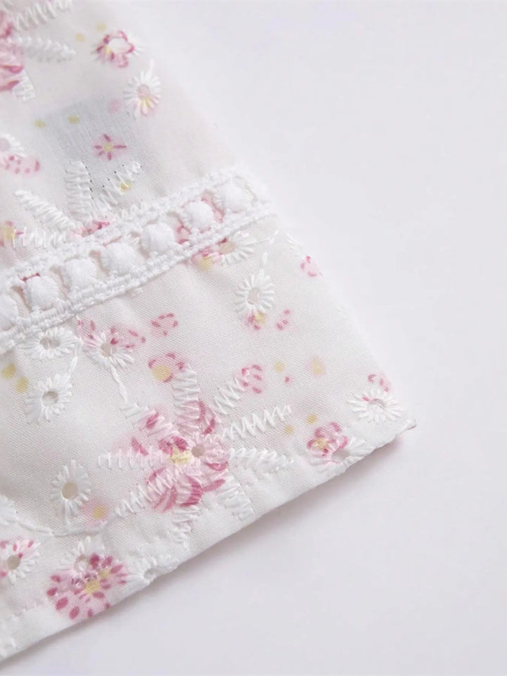 Stilren vit blommig cami topp med knytning fram för kvinnor. Ett bekvämt ärmlöst linne för sommar och fritid.