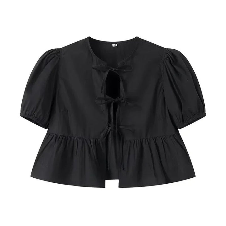 Vit damtopp med volang, knytning och trendiga puffärmar. Perfekt för sommar och en feminin stil.