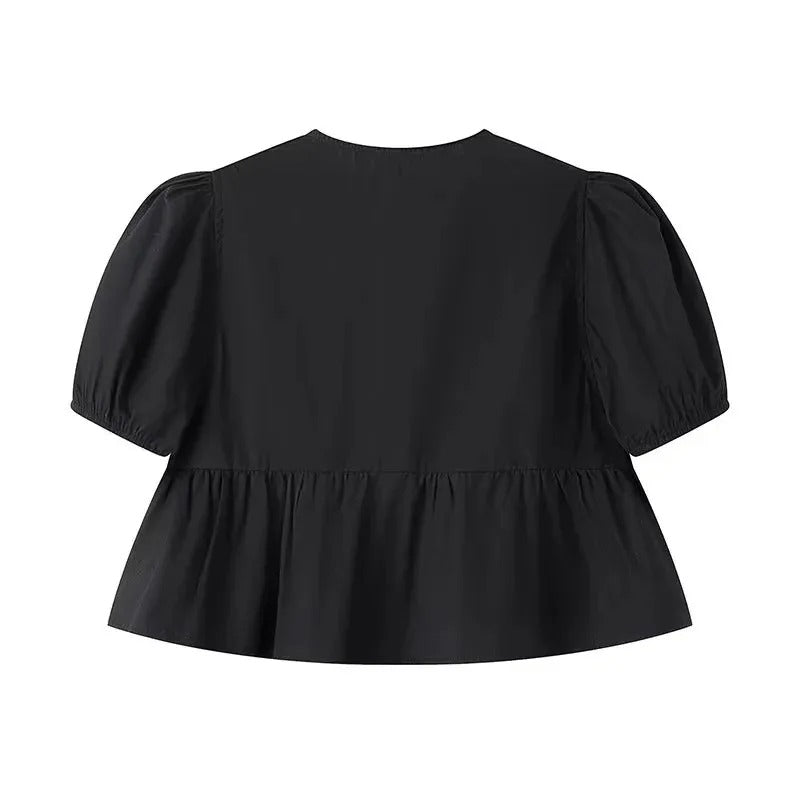 Casual knyttopp för damer med volangdetaljer och puffärmar. En stilren sommarstil i svart.