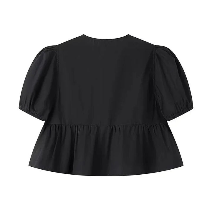 Casual knyttopp för damer med volangdetaljer och puffärmar. En stilren sommarstil i svart.